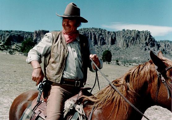 John Wayne in The UNdefeated on horse with gun